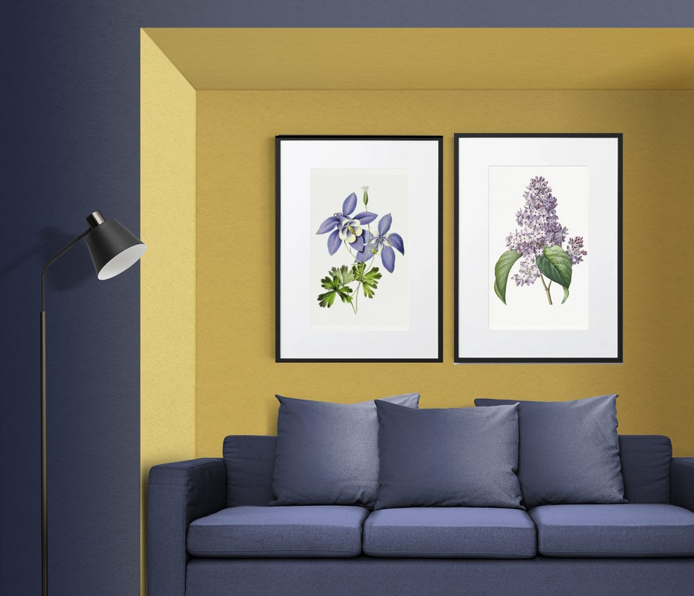 Printed botanical wall art place on bright yellow wall with purple sofa